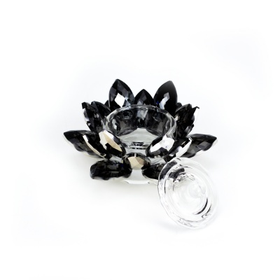 Vela em vidro transparente e preto com formato de flor e fundo branco