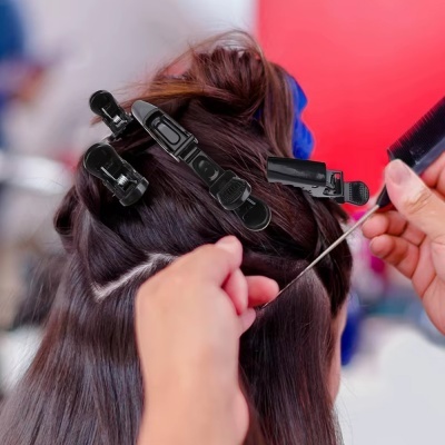 Pessoa com cabelo castanho a ser penteada com molas de cabelo e um pente prateado