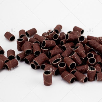 Capas de lixa marrons cilíndricas para lixagem sobre fundo branco