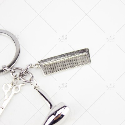 Chaveiro metálico com miniaturas de pente, tesoura e secador