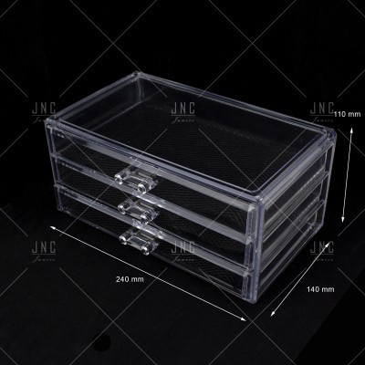 Organizador acrílico transparente de três gavetas sobre fundo preto