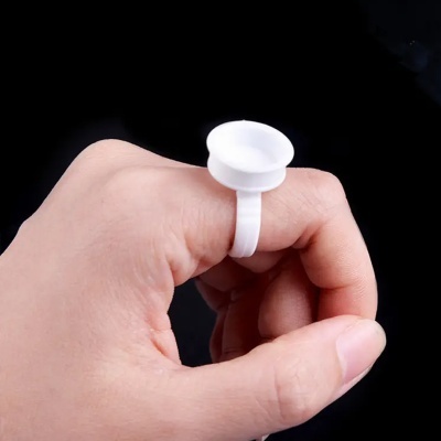 Anel plástico branco com suporte circular na mão