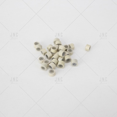 Pequenos anéis cilíndricos creme com interior cinza sobre fundo branco