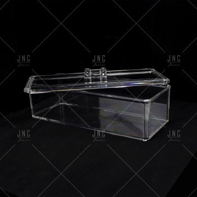 Caixa retangular transparente de acrílico com tampa e alça dupla numa superfície preta
