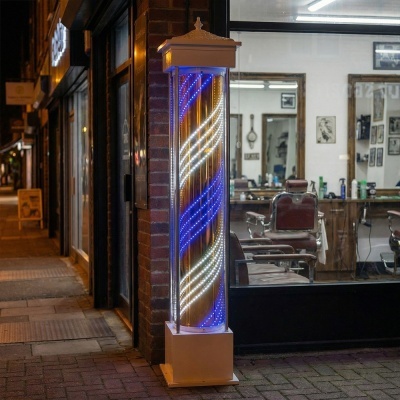 Poste luminoso LED azul e branco fora de barbearia com cadeiras castanhas