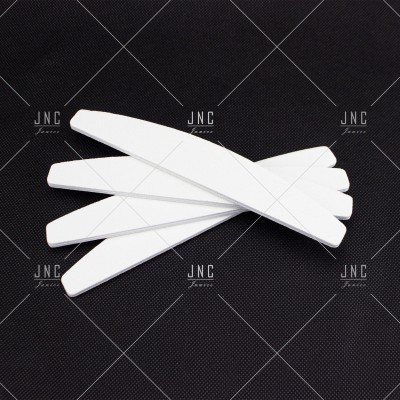 Cinco lixas de unha brancas empilhadas sobre fundo preto