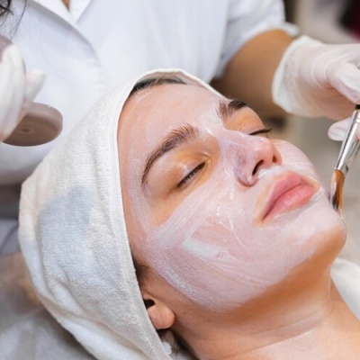 Mulher a receber máscara facial num ambiente de spa.