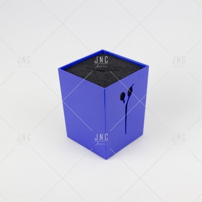 Caixa azul com auscultadores pretos em suporte de espuma preta