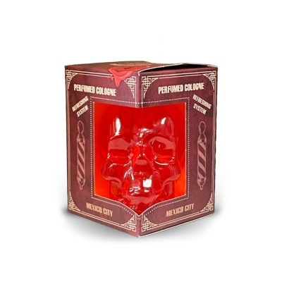 Colónia perfumada em frasco de caveira vermelho dentro de caixa vermelha com texto em branco