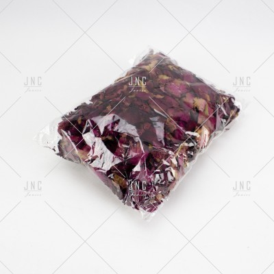 Pacote transparente com pétalas de rosa secas vermelhas e roxas.