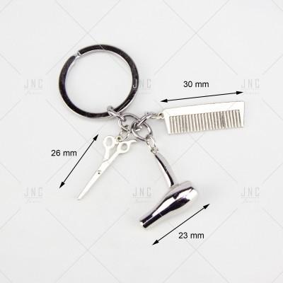 Porta-chaves metálico com tesouras, pente e secador de cabelo prateados em fundo branco