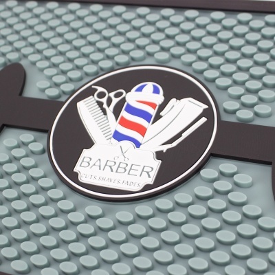 Placa redonda preta de barbeiro com ilustrações de navalha, pente, tesoura, barbeador elétrico e poste de barbearia sobre superfície cinza texturizada