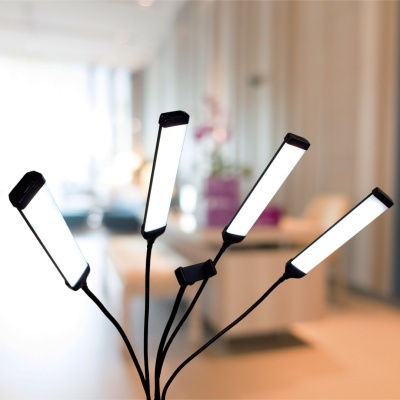 Lâmpada LED de quatro braços flexíveis com luz branca acesa em interior