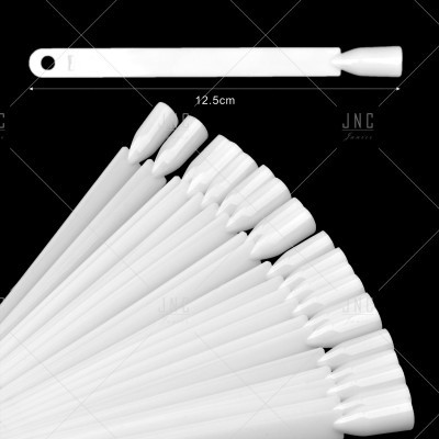 Paletas de unhas artificiais brancas em leque sobre fundo preto