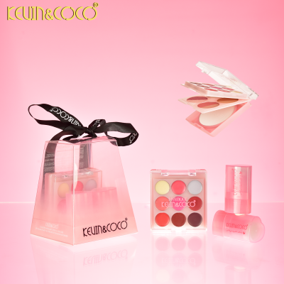 Conjunto de maquilhagem KEVIN&COCO com paleta, pó compacto e batons em fundo rosa