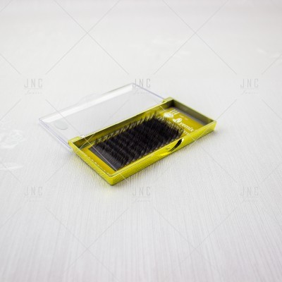 Estojo amarelo com extensão de pestanas negras e tampa transparente