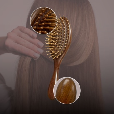 Escova de cabelo de madeira com cerdas em fundo de cabelo castanho liso