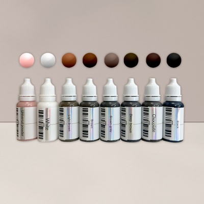 Frascos de tinta em tons de pele com tampas brancas alinhados em superfície plana.