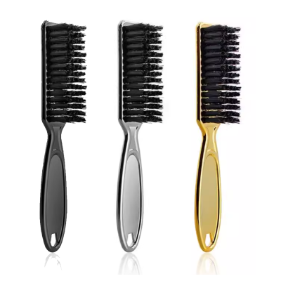 Três escovas para cabelo com cerdas pretas e cabos nas cores preta, prateada e dourada