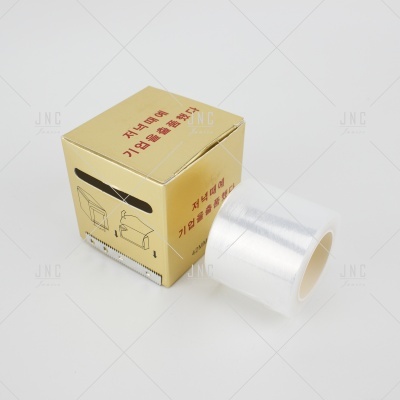 Embalagem dourada com texto em coreano e rolo de película adesiva transparente