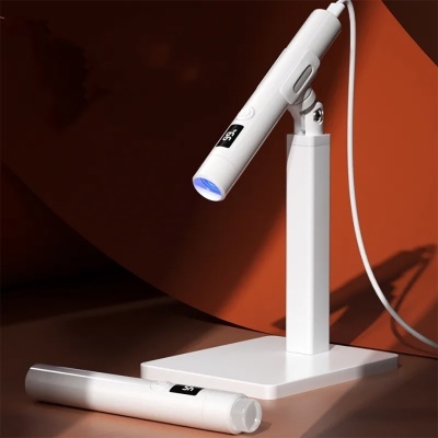 Dispositivos eletrónicos brancos com ecrã e luz azul em fundo castanho