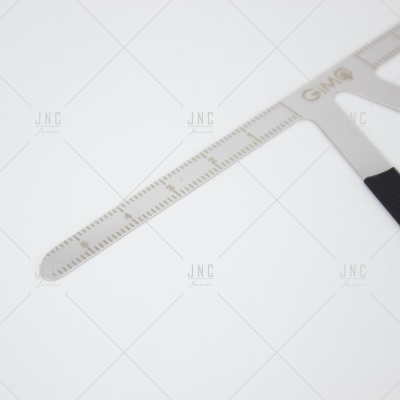 Régua metálica prateada com graduação e inscrição dourada GMQ