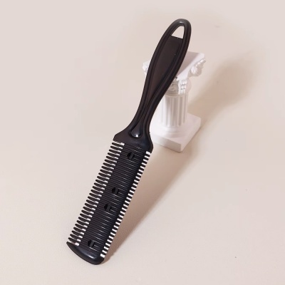 Pente preto de plástico com dentes espaçados e punho ergonómico ao lado de suporte branco