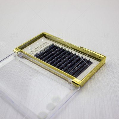 Estojo dourado com pestanas postiços pretos em camadas e tampa transparente