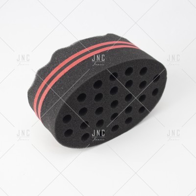 Esponja preta com riscas vermelhas e furos circulares