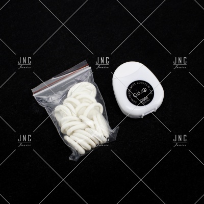 Saco com argolas elásticas brancas e estojo branco redondo com etiqueta preta