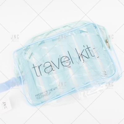 Bolsa transparente azul clara com frascos e texto 'travel kit'