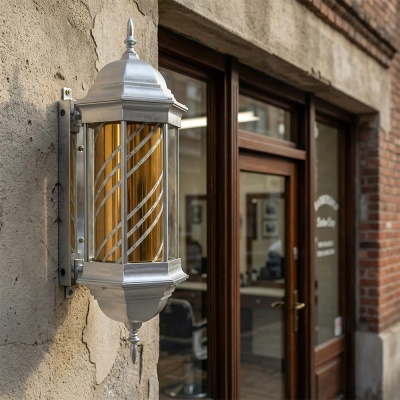 Lanterna de parede em metal prateado com vidro amarelo e detalhes espiralados