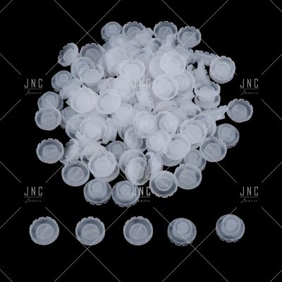 Tampões plásticos brancos pequenos sobre fundo negro