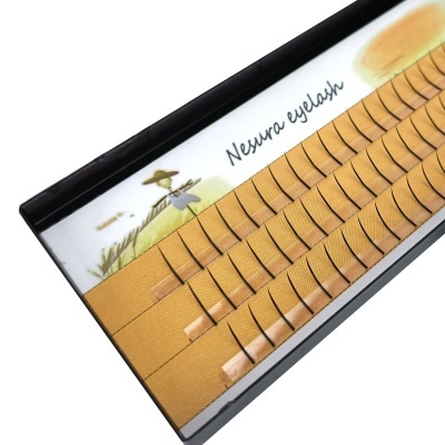 Caixa preta com pestanas postiços castanhas claras organizadas em fileiras cantando 'Nexura eyelash'