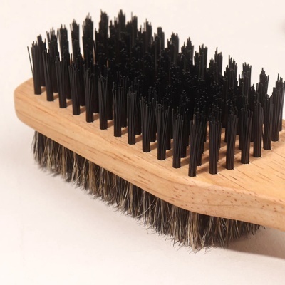 Escova de madeira com cerdas pretas e naturais em fundo branco