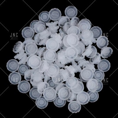 Tampões plásticos brancos circulares empilhados em fundo preto