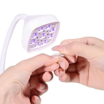 Dispositivo LED branco com 9 luzes e mãos a aplicar unha postiça