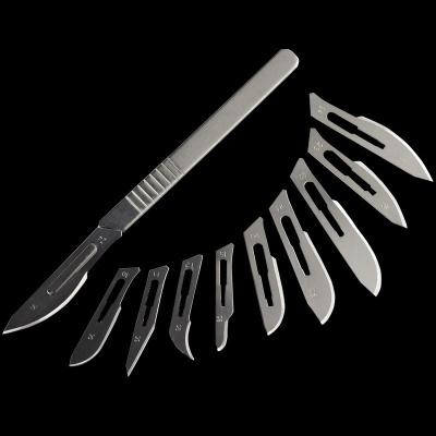 Conjunto de bisturis metálicos com várias lâminas em fundo preto