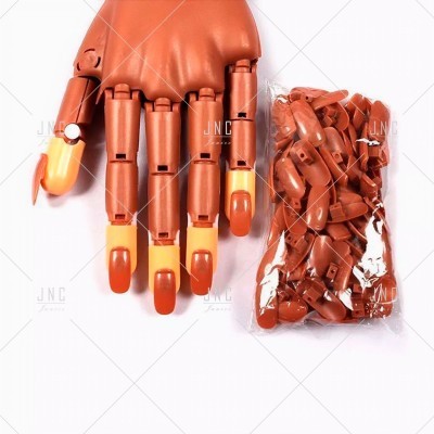 Mannequim de mão de madeira castanha com unhas em tons de laranja e bege e peças adicionais embaladas