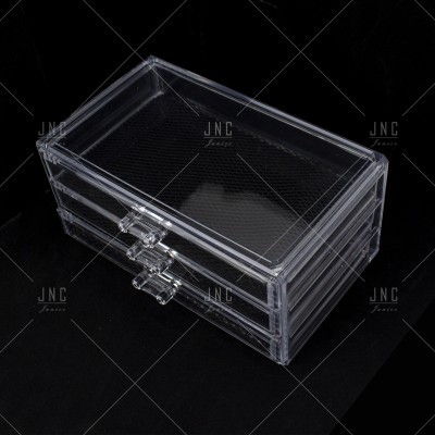 Caixa de armazenamento transparente com três gavetas sobre fundo preto