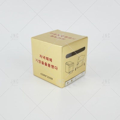 Caixa dourada pequena com texto em coreano e desenho no fundo branco