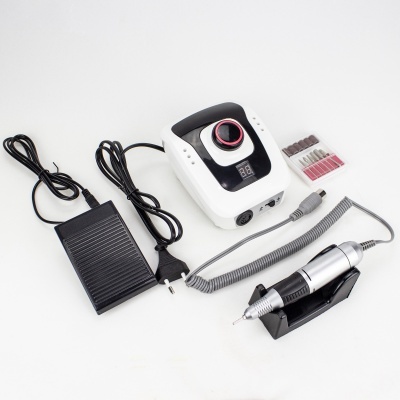 Máquina eléctrica de manicure com pedal e brocas sobre fundo branco