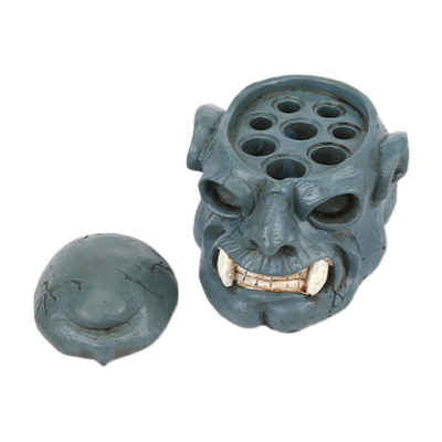 frasco azul em forma de cabeça monstruosa com tampa e buracos