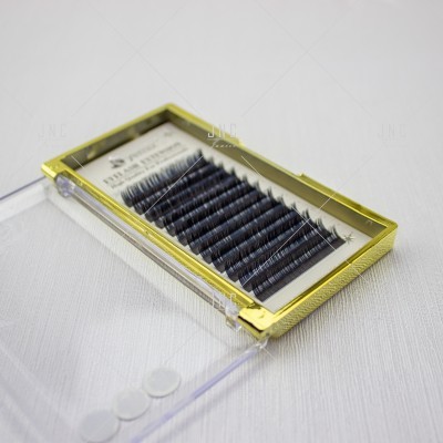 Estojo com pestanas artificiais pretas em filas dentro de caixa transparente com moldura dourada