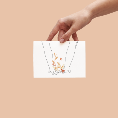 Cartão branco com desenho minimalista de dois braços entrelaçados e flores em tons de laranja, vermelho e bege, fundo bege.