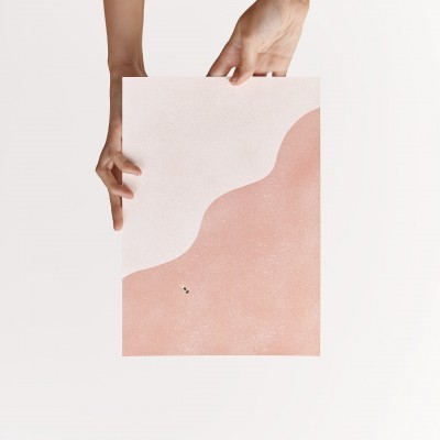 Folha com design abstrato em tons de rosa segurada por duas mãos