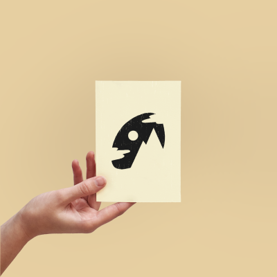 Cartão creme com símbolo preto de cabeça de peixe segurado por mão