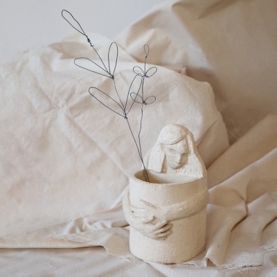 Vaso decorativo em cerâmica com figura humana abraçando e ramo de arame