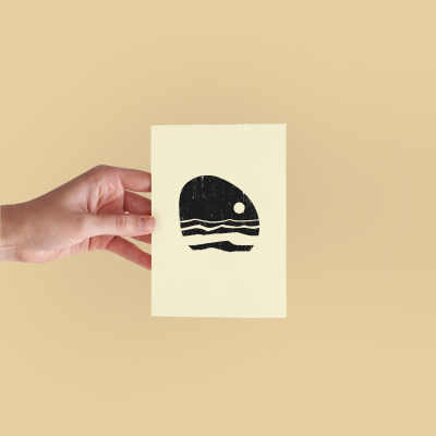 Mão segurando cartão com ilustração preta de sol e ondas