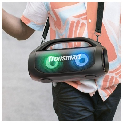 Coluna portátil preta Tronsmart com luzes verdes e azuis sendo transportada